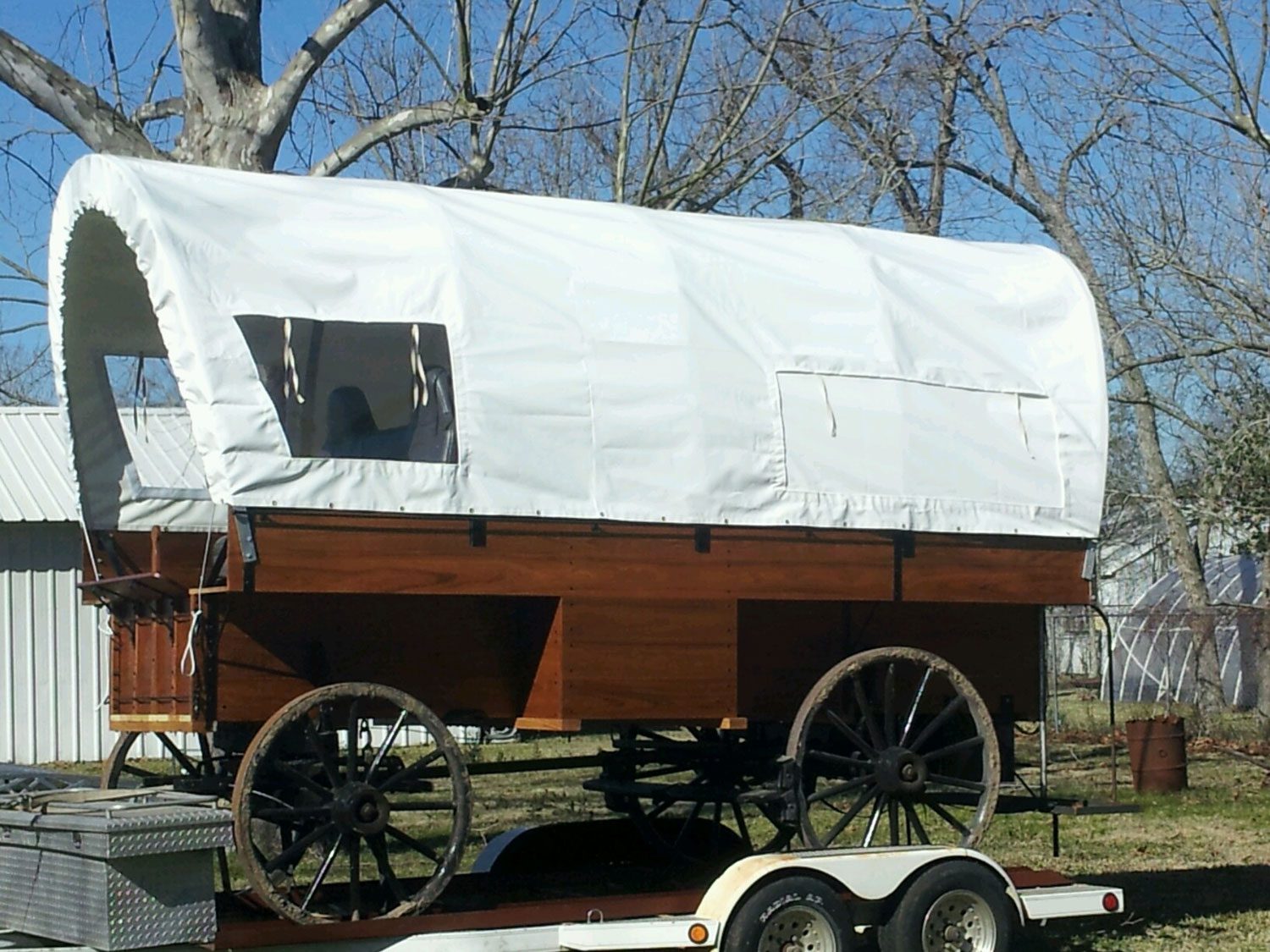 Covered wagon on a trailer outdoors.