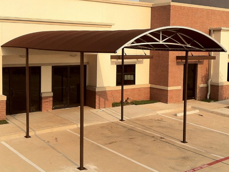 Covered entrance with metal canopy and poles.