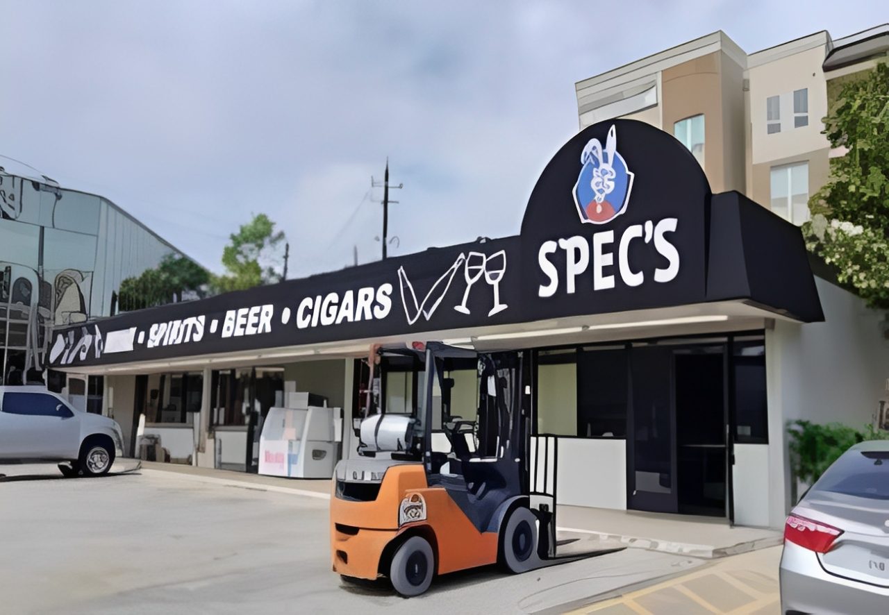 Storefront with forklift and signage outside.