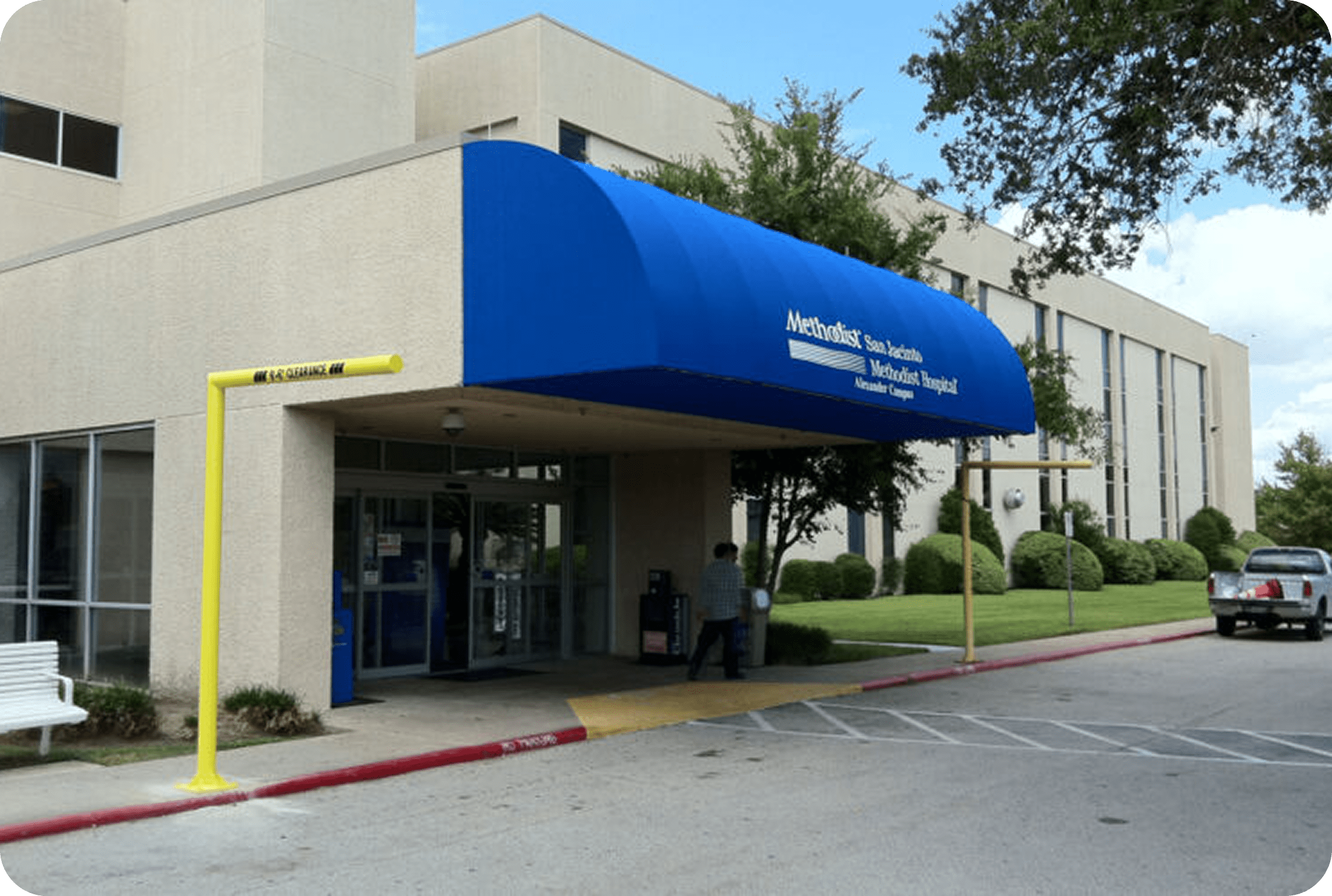 Hospital entrance with blue canopy and signage.